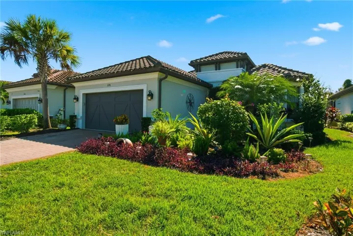 Mediterranean / spanish home featuring stucco siding, a front lawn, an attached garage, and a tiled roof