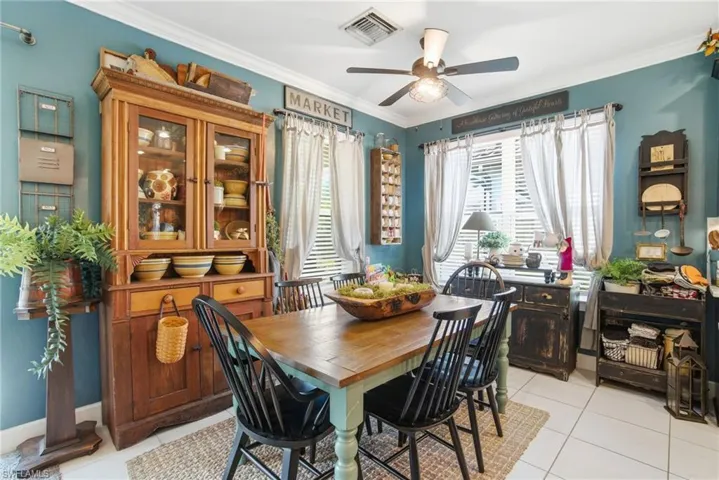 Dining space featuring ornamental molding, light tile patterned floors, and a ceiling fan