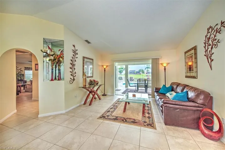 Tiled living room featuring vaulted ceiling