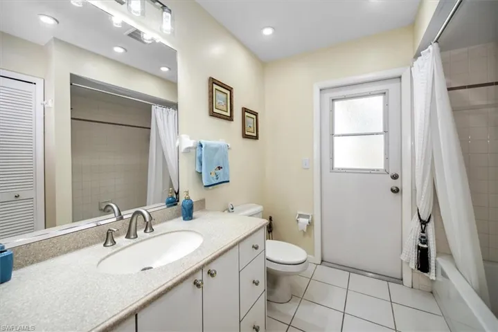 Full bathroom featuring tile patterned flooring, shower / bath combo, toilet, and vanity