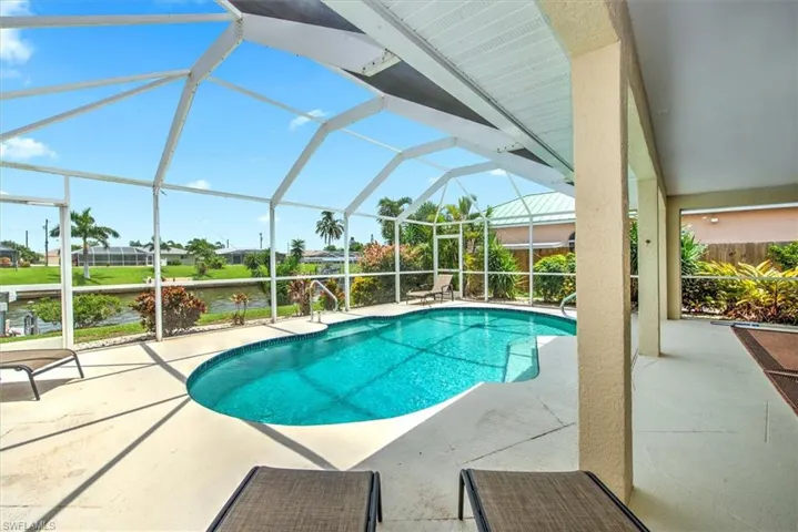 View of swimming pool featuring glass enclosure and a patio area