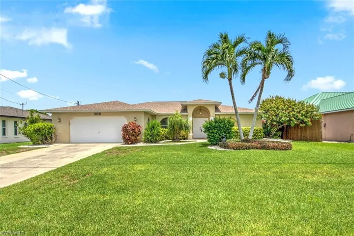 View of front of house with a garage and a front lawn
