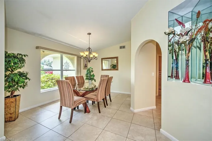 Tiled dining area featuring an inviting chandelier and lofted ceiling