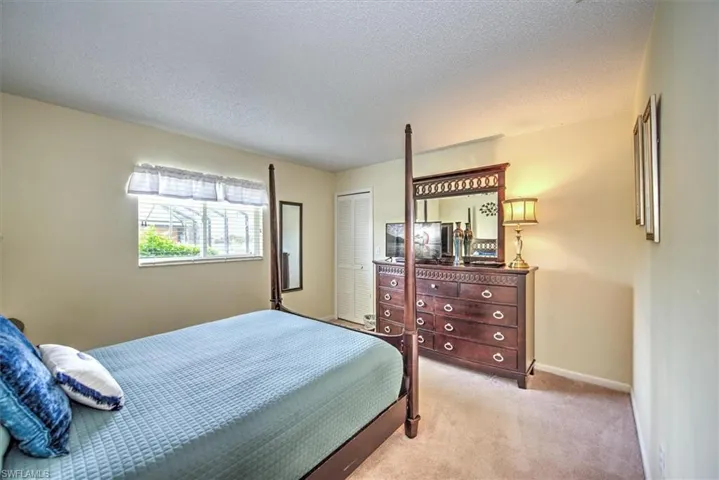 Bedroom featuring light carpet, a closet, and a textured ceiling