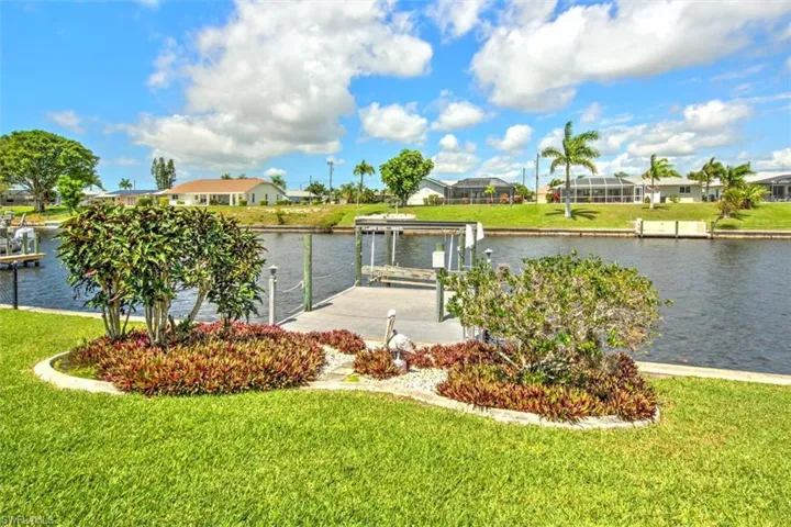 Dock area featuring a water view, a yard, and a lanai