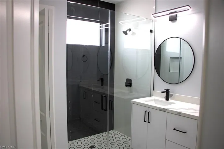 Full bathroom with vanity and a stall shower
