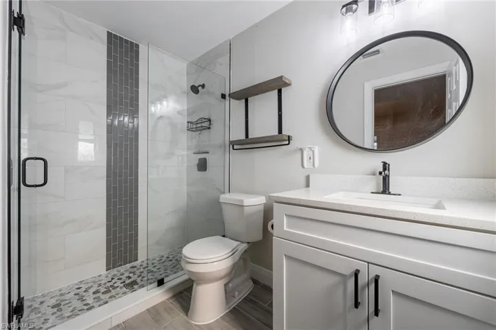 Kitchen with wood tiled floors, white cabinets, a chandelier, dishwasher, and decorative backsplash