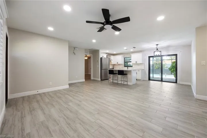 Living area with recessed lighting, wood finish floors, a ceiling fan, and a chandelier