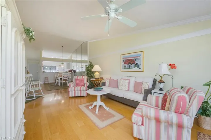Living room with wood finished floors and ornamental molding