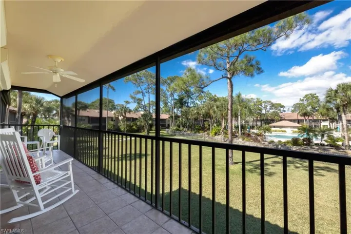Sunroom / solarium with a ceiling fan, a balcony, and a residential view