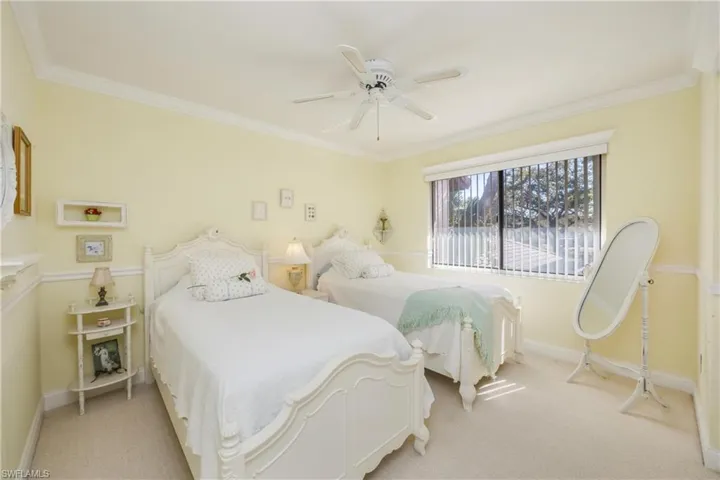 Carpeted bedroom featuring crown molding and a ceiling fan