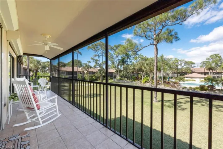 Sunroom with a balcony, ceiling fan, and a residential view