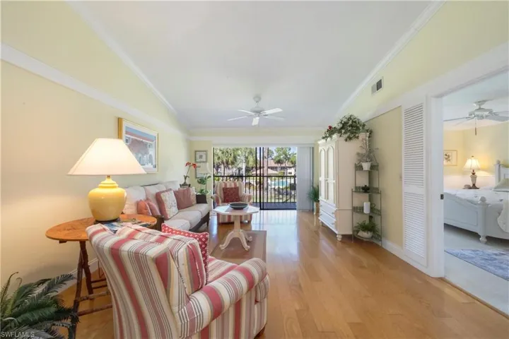 Living area featuring a ceiling fan, light wood-style floors, and ornamental molding