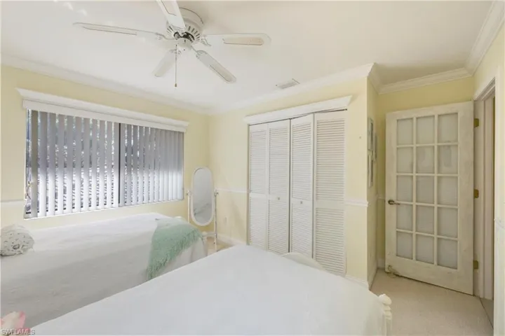 Carpeted bedroom with crown molding, a closet, and ceiling fan