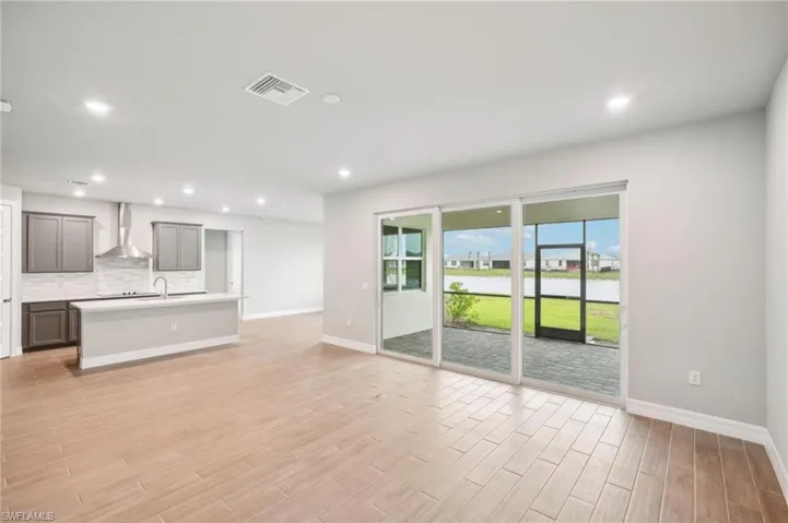 Unfurnished living room with light hardwood / wood-style flooring and sink