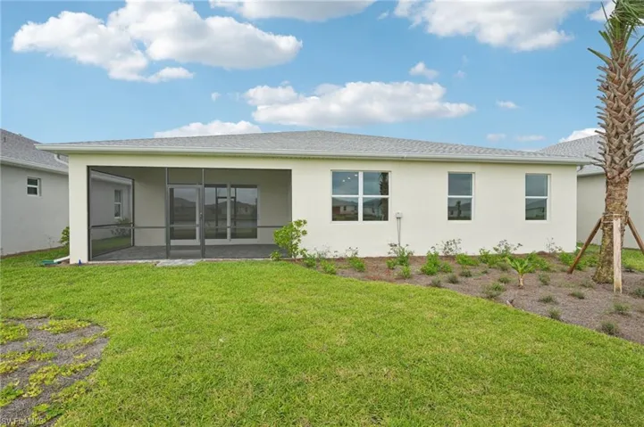 Back of property with a lawn, a sunroom, and a patio area