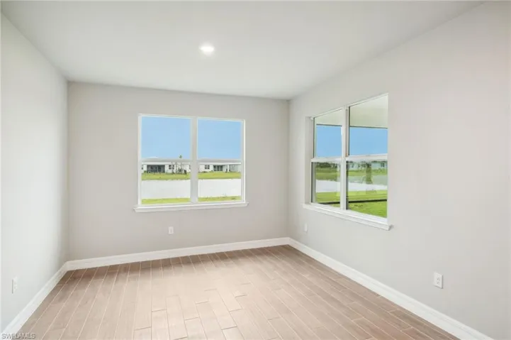 Empty room with light hardwood / wood-style floors and a water view