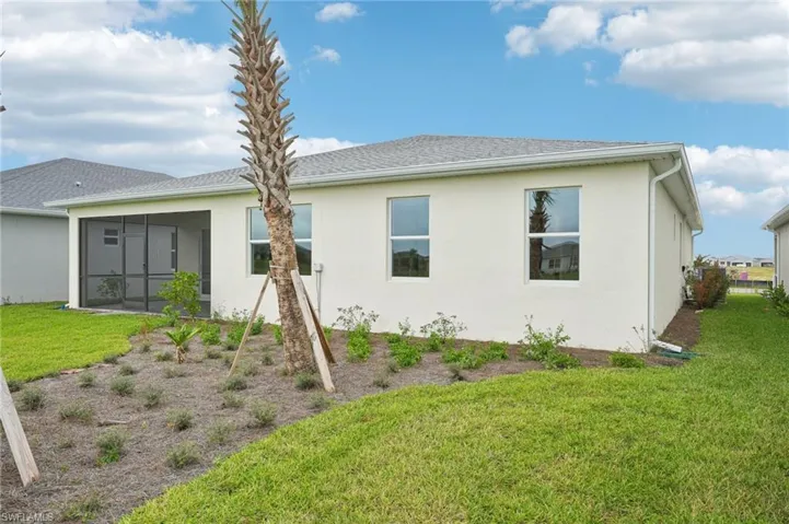 Rear view of house featuring a lawn and a sunroom