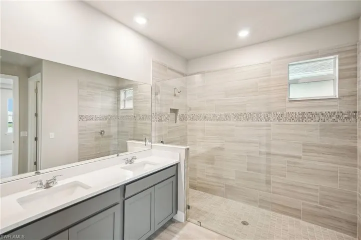 Bathroom with vanity and tiled shower