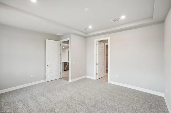 Unfurnished bedroom with light carpet