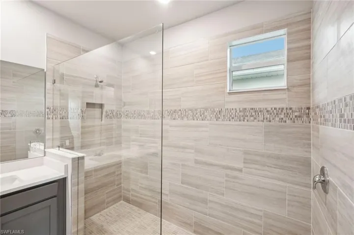 Bathroom with vanity and tiled shower