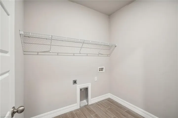 Clothes washing area featuring hardwood / wood-style floors, washer hookup, and electric dryer hookup