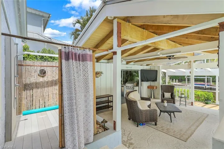 Outdoor living with pool shower, outdoor kitchen and relaxation area.