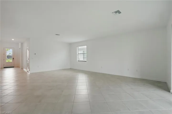 Empty room featuring light tile patterned floors, plenty of natural light, baseboards, and recessed lighting