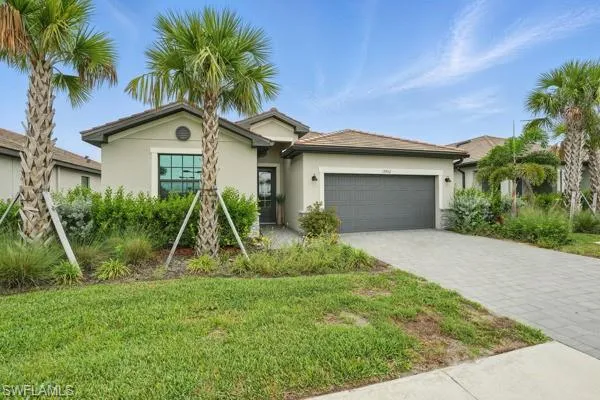 Ranch-style house featuring stucco siding, an attached garage, decorative driveway, and a front yard