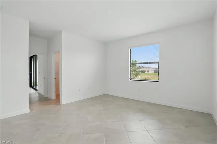 Spare room with light tile patterned flooring and baseboards