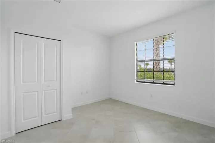 Unfurnished bedroom with baseboards, a closet, and light tile patterned floors