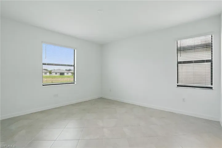 Empty room featuring baseboards and light tile patterned floors