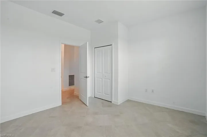 Spare room with baseboards and light tile patterned floors