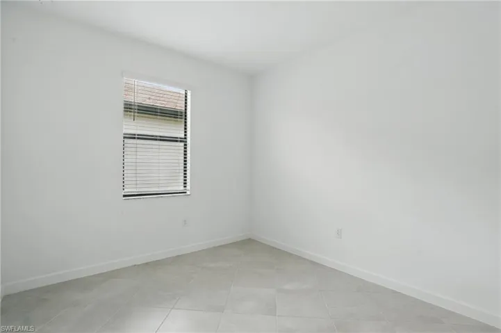 Empty room featuring baseboards and light tile patterned floors