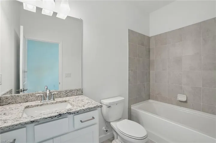 Bathroom with vanity, toilet, and washtub / shower combination