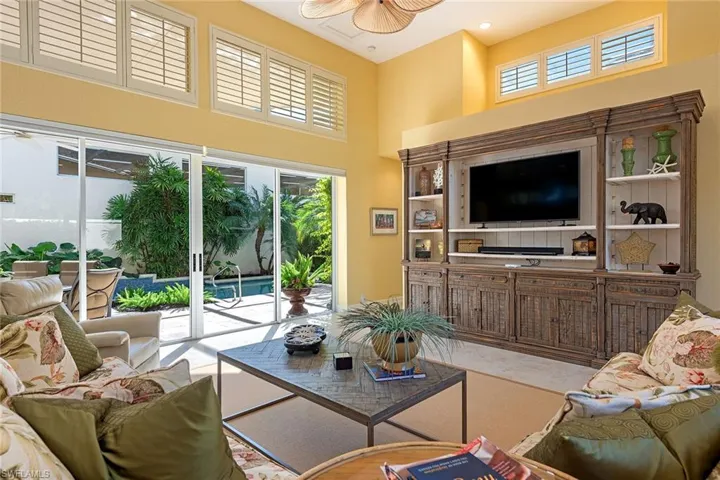 Living room with a towering ceiling and ceiling fan
