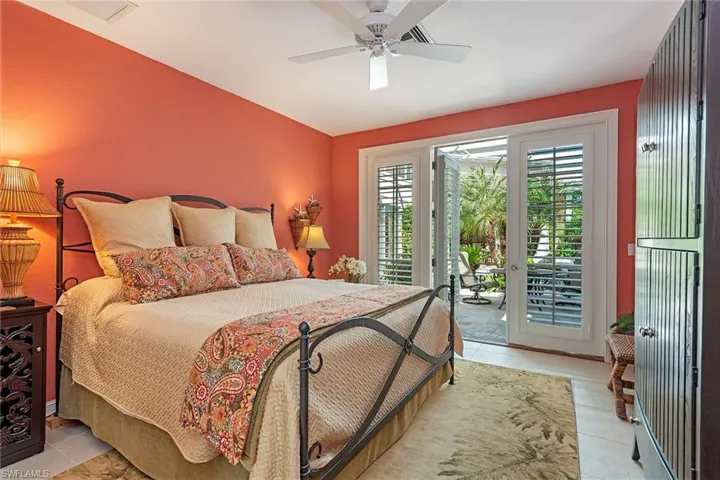 Bedroom featuring light tile patterned floors, access to exterior, ceiling fan, and vaulted ceiling
