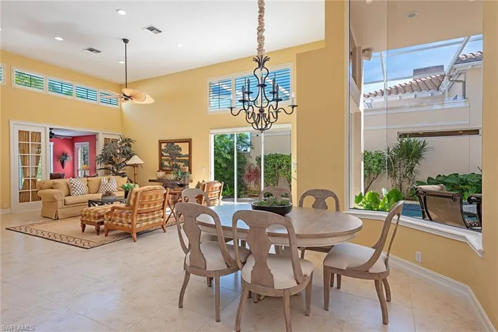 Dining room featuring a towering ceiling, a chandelier, light tile patterned floors, and recessed lighting