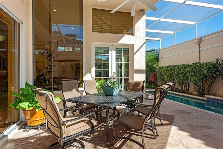 View of patio featuring french doors, a lanai, outdoor dining space, and a sunroom