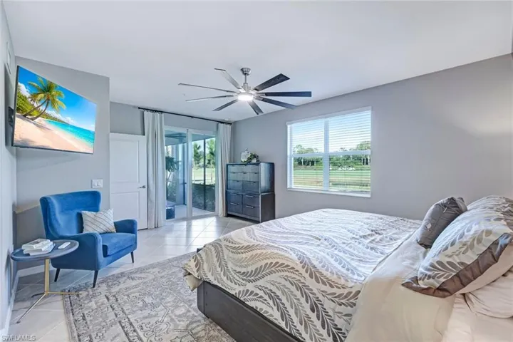 Neutral-toned room featuring tile flooring, a multi-blade ceiling fan, and sliding glass doors to lanai area with exterior access