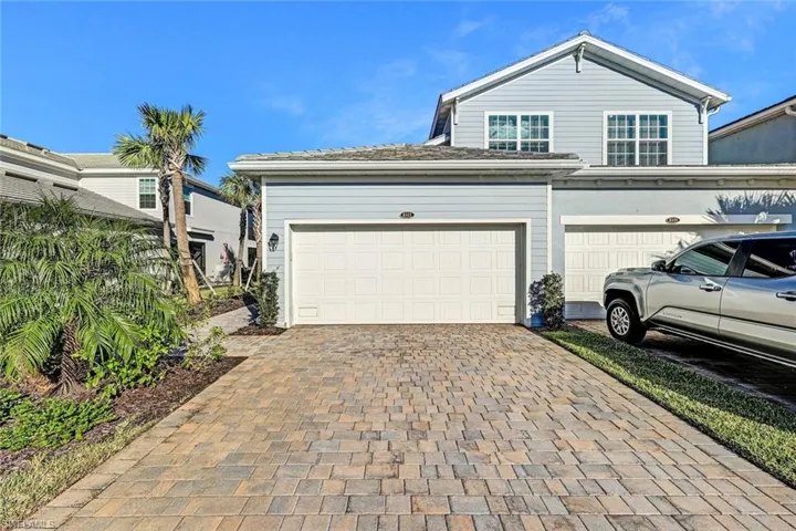 FIRST FLOOR one story residence with an attached two-car garage with paneled doors, and a decorative paver driveway