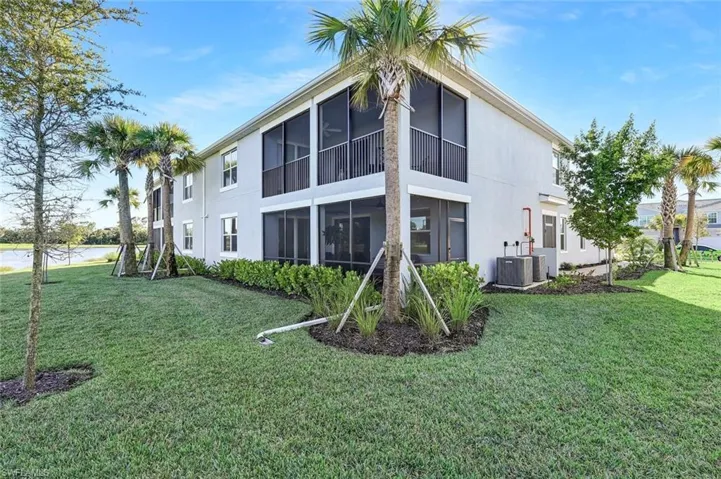 FIRST FLOOR exterior featuring a light-toned stucco facade, multi-level screened-in lanais, and manicured landscaping with mature palm trees