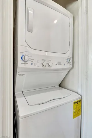 Washroom featuring stacked washing maching and dryer