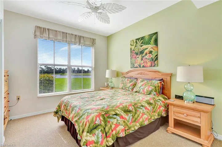 Carpeted bedroom featuring ceiling fan