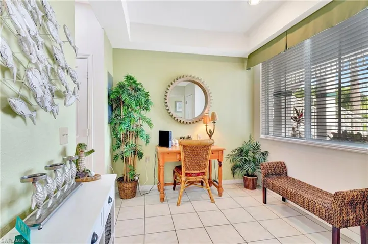 Home office featuring light tile flooring and a raised ceiling