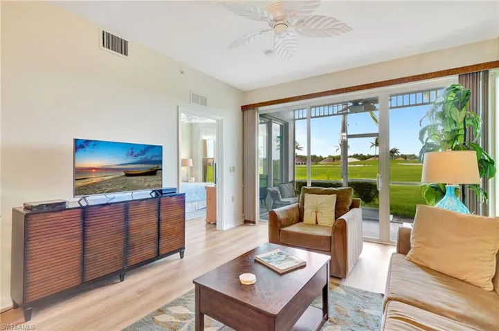 Living room with a wealth of natural light, ceiling fan, and light hardwood / wood-style floors