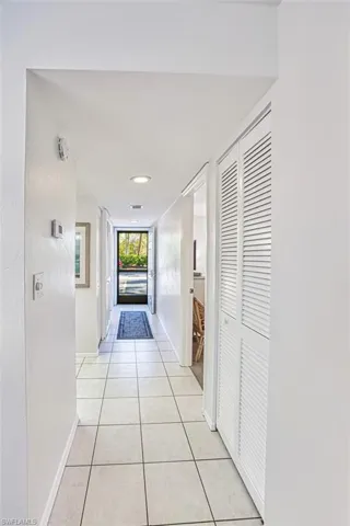 Hallway with light tile patterned floors and baseboards
