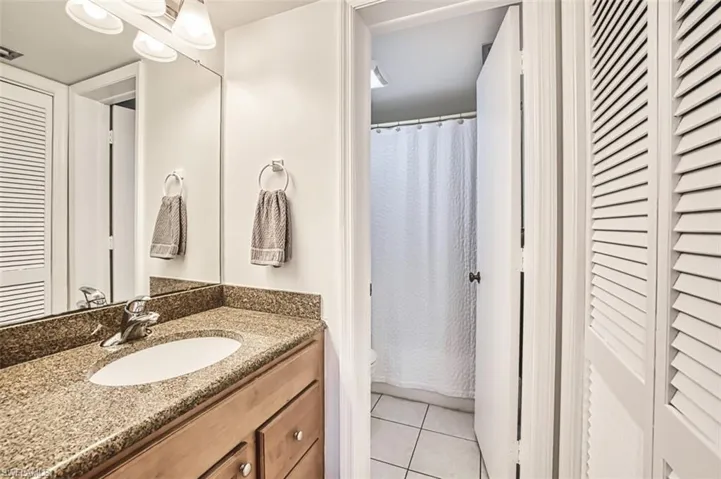 Bathroom with tile patterned flooring, vanity, toilet, and a shower with curtain