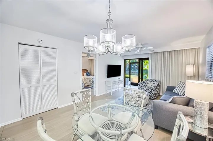 Dining area featuring a ceiling fan, light wood-style flooring, a chandelier, and baseboards