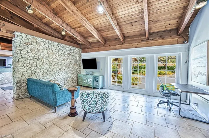 Living area with wood ceiling, rail lighting, and stone finish floors